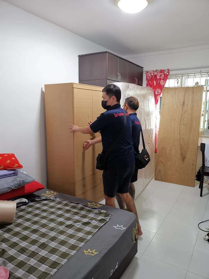 two house movers preparing to dismantle cupboard