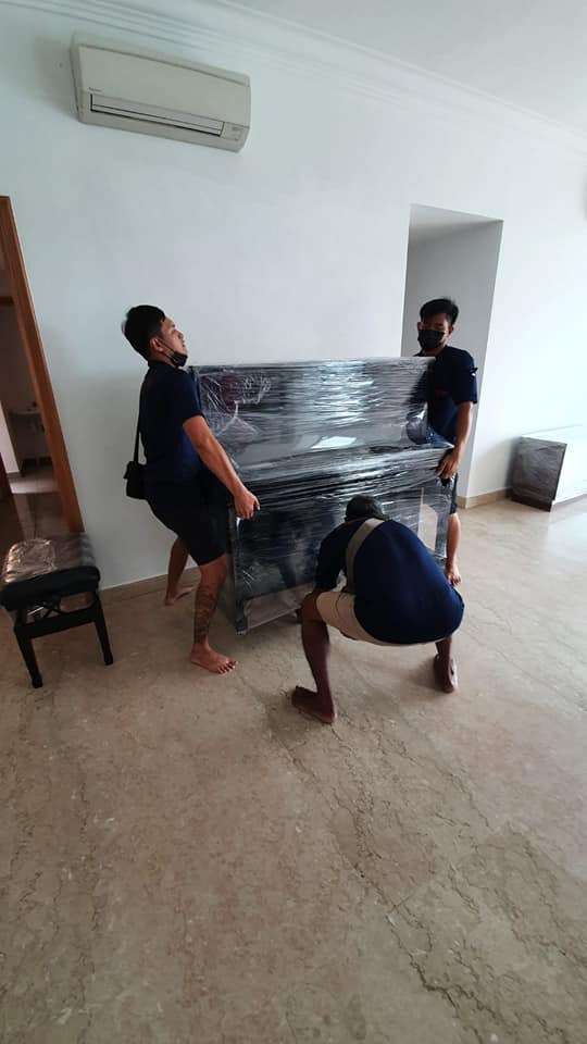 3 people lifting the piano to move