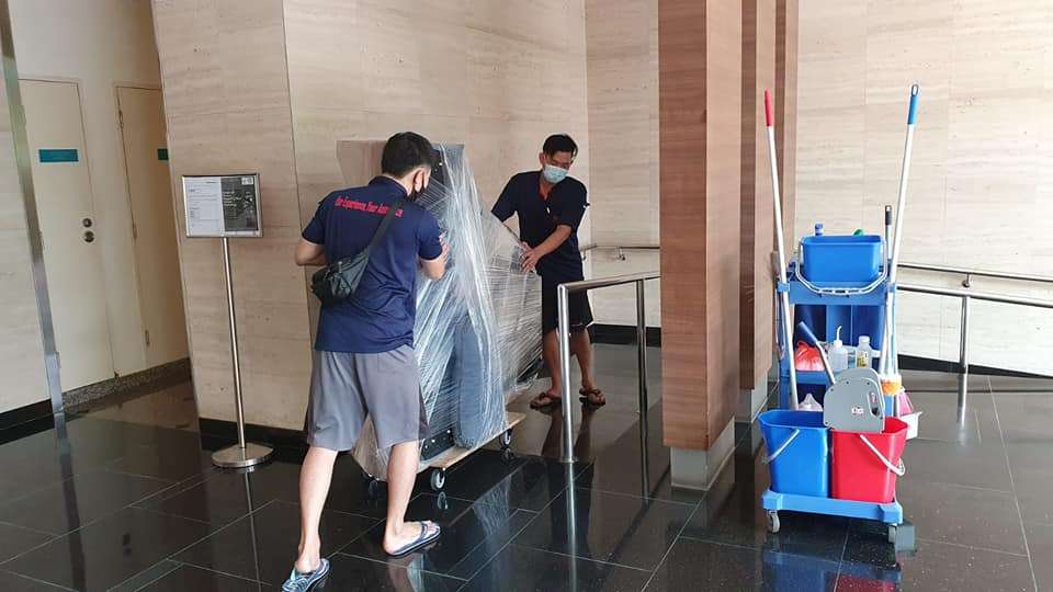 2 man moving piano using a trolley