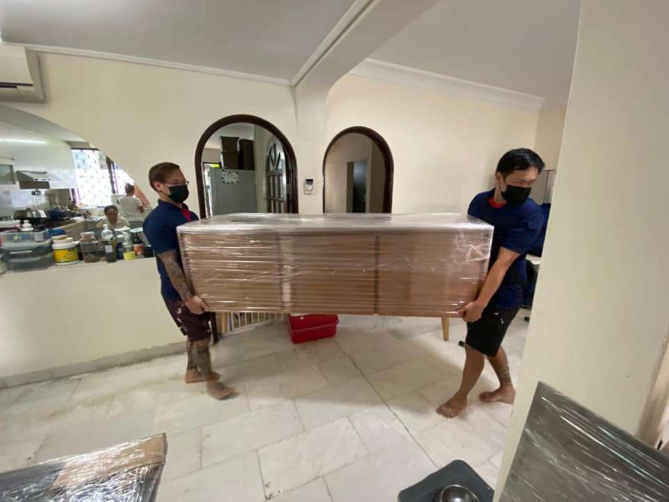 two staff carrying wrapped sideboard